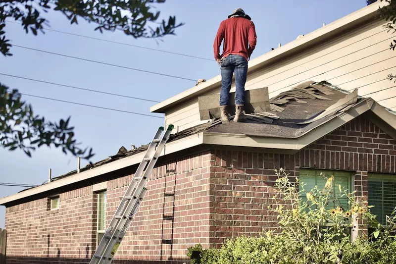 Professional roofer working on a residential roof in Hays